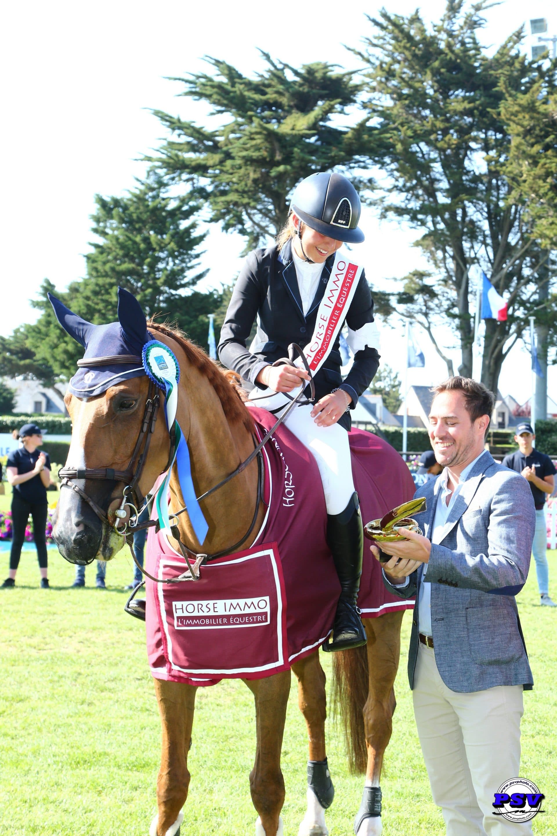 Paloma De Crozals reçoit le trophée de la part de Guillaume Carlier, Directeur Horse Immo.